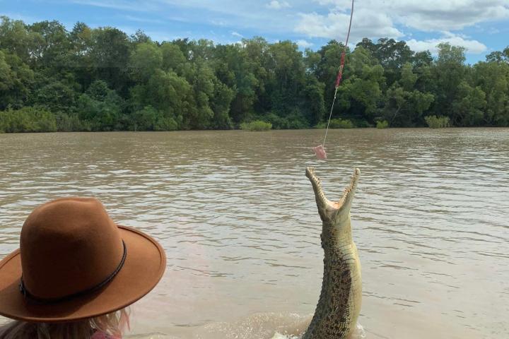 a woman sitting next to a body of water